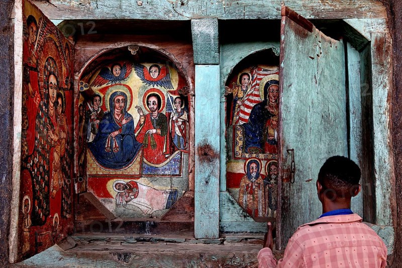 Person in front of icons in a decorated wooden structure, Tana Lake, Ura Kidhane Mihret, Ethiopia