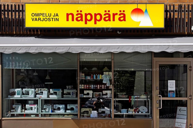Shop front with yellow Näppärä sign and shop window of a textile shop, Rovaniemi, Finland