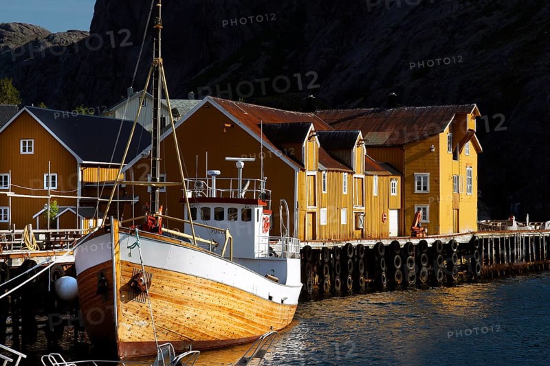 Yellow wooden house and boat in Nusfjord harbour, Flakstadøy, Nusfjord, Flakstadøy, Norway