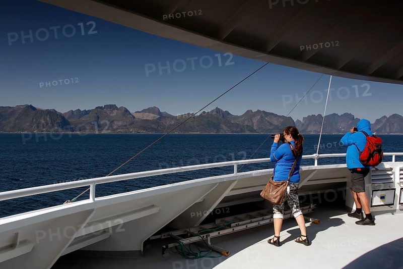 Passengers on a ferry look at the Lofoten Mountains, Lofoten, Norway