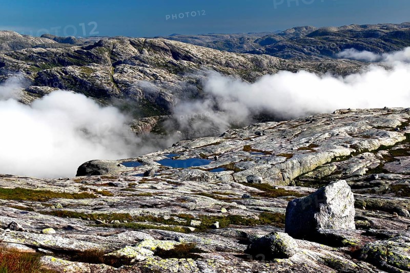 Wide plateau with clouds over a rocky landscape in Kjerag, Lysefjord, Rogaland, Norway