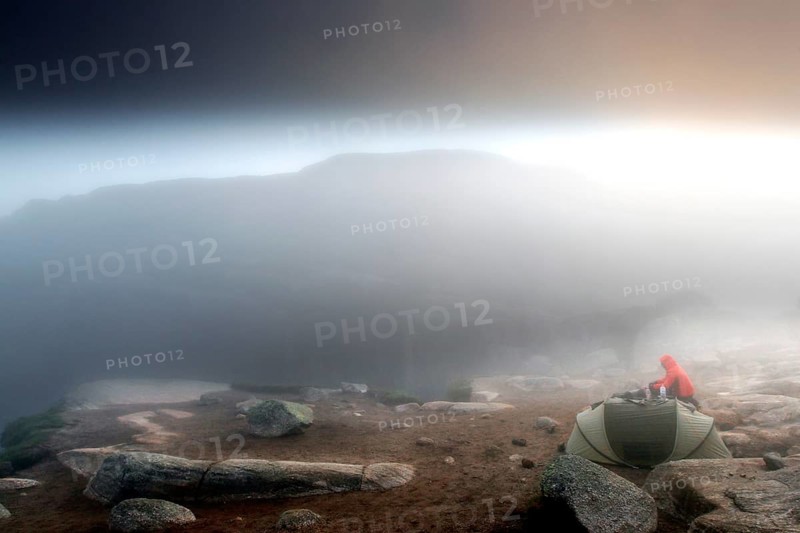Tent at sunrise in thick fog with glowing horizon on a plateau, Lysefjord, Rogaland, Norway