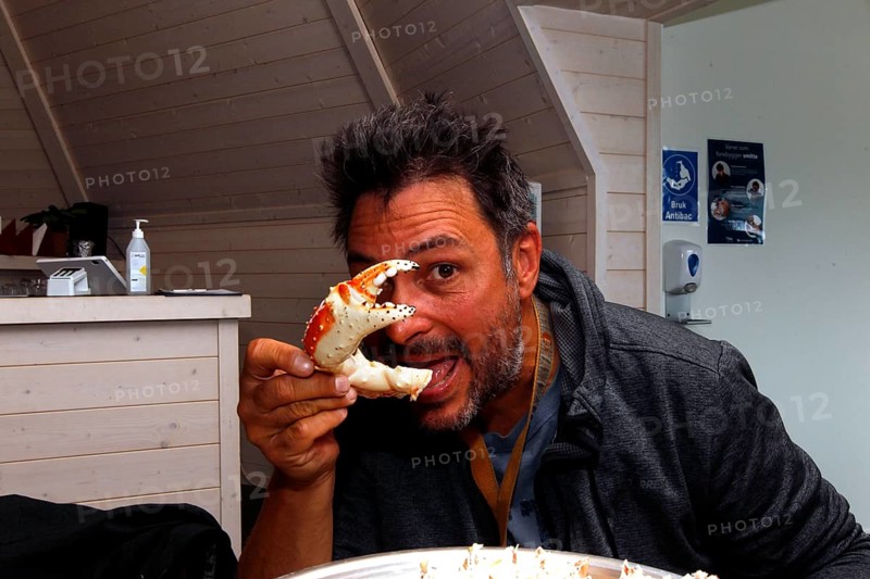 Person eats king crab in a restaurant in Sarnes, Sarnes, Norway