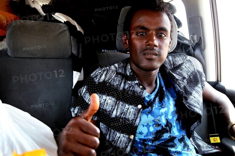 Young man in car in Berhaile showing thumbs up, smiling gesture, Berhaile, Ethiopia