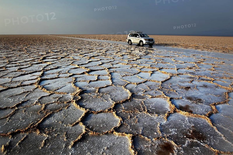 Landcruiser stands in an extensive salt desert with distinctive cracks, Dallol, Asale, Ethiopia