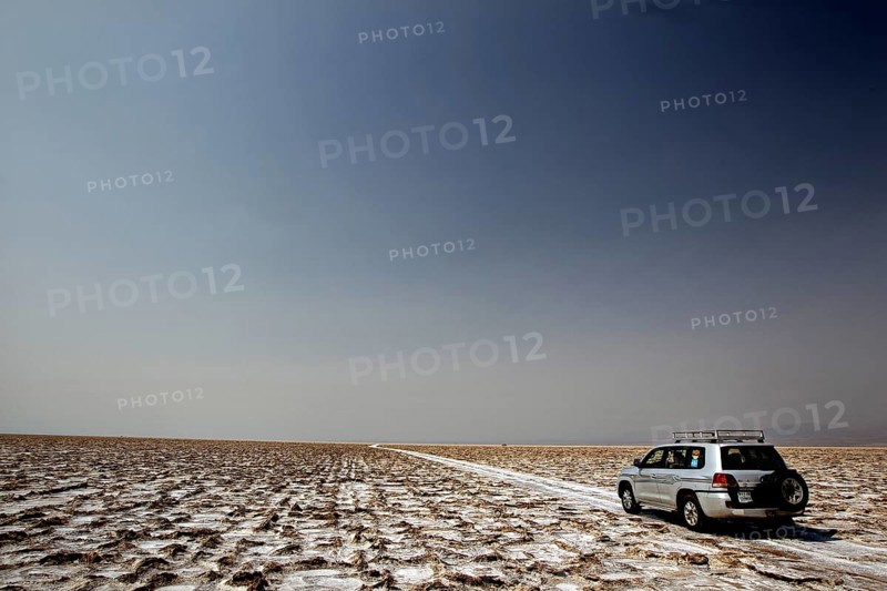 An off-road vehicle on a wide salt crust in the Dallol Desert, Dallol, Afar, Ethiopia