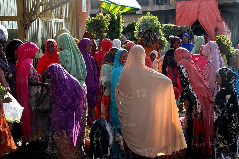 People wearing colorful robes at a busy market, Awaday, Ethiopia