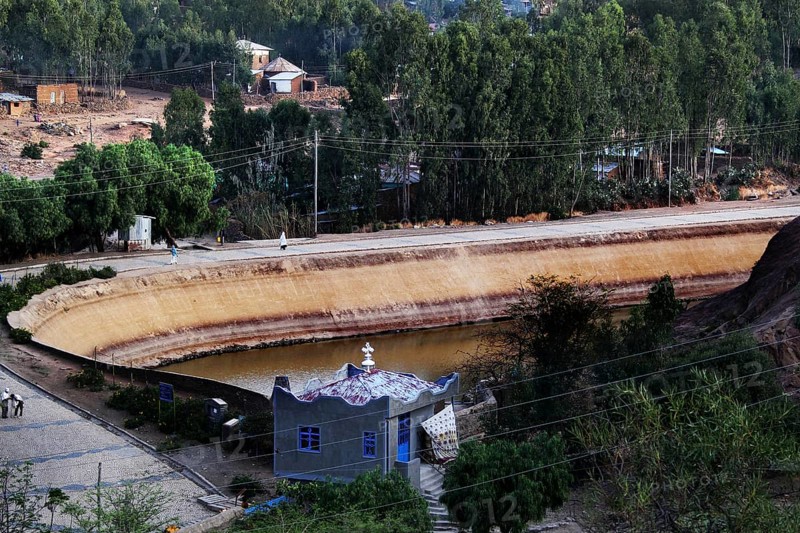 Historic view of Queen of Sheba's pond with lush green surroundings in Axum, Axum, Ethiopia