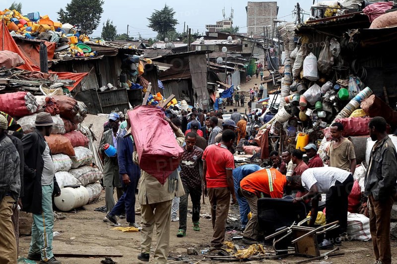 People carry large bags on their shoulders through the bustling Mercato in Addis Ababa, Addis Ababa, Ethiopia