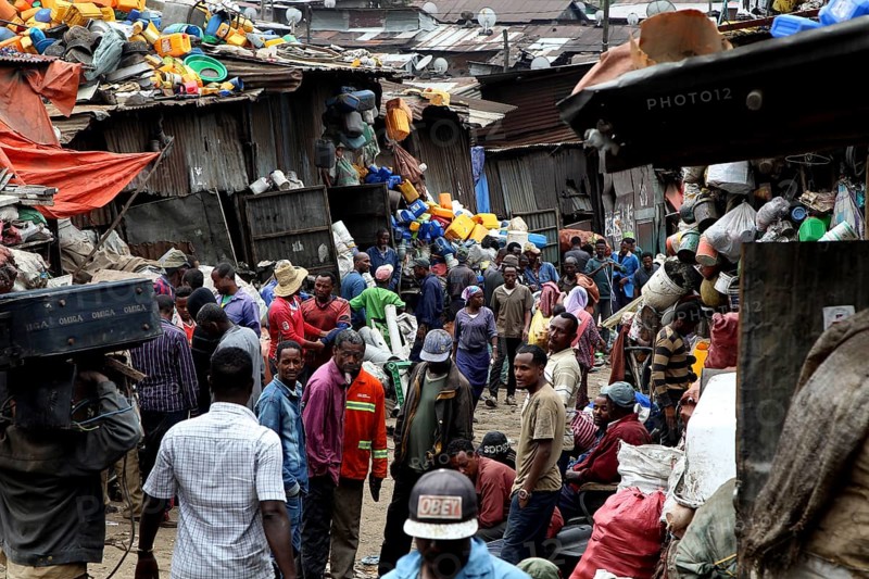 Large crowds of people on the busy Mercato in Addis Ababa, surrounded by colorful fabrics, Addis Ababa, Ethiopia