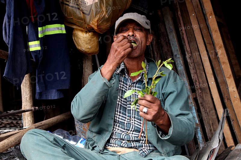 A man sits and chews on plants on the Mercato in Addis Ababa, Addis Ababa, Ethiopia