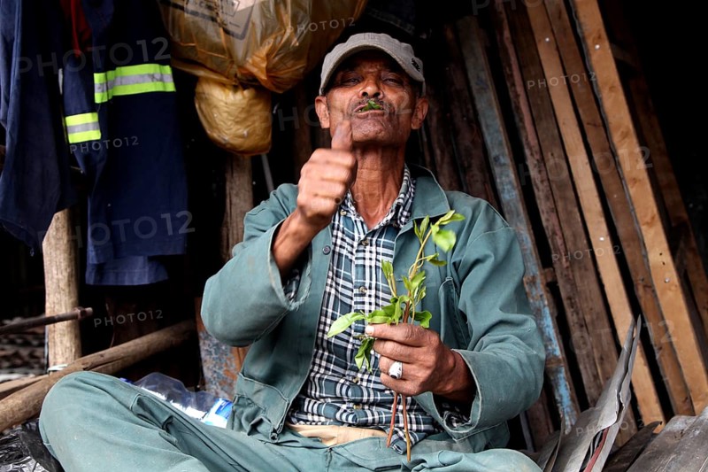 Market scene in Mercato, Addis Ababa. A man points thumbs up while offering plants, Addis Ababa, Ethiopia