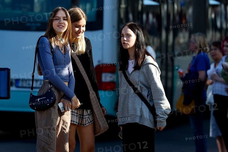 Three young woman standing smiling on a busy street in Tallinn, Tallinn, South Alinn, Estonia