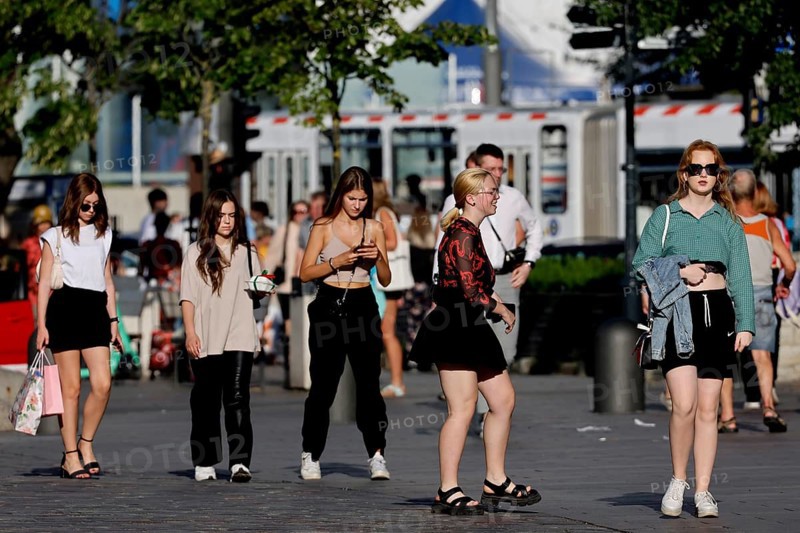 People stroll through the sunny old town, dressed in casual summer clothes, Tallinn, Harju, Estonia