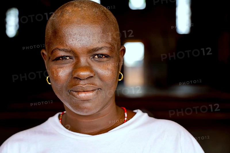 Close-up of smiling woman wearing earrings in relaxed atmosphere, Bouké, region, Côte d'Ivoire