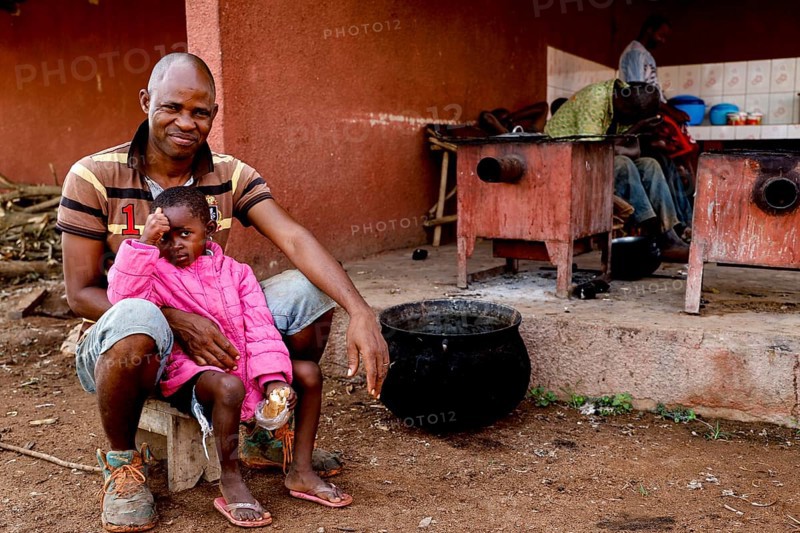 Worker sitting with his daughter in a rehabilitation center for the mentally ill, Nongotanakaha, null, Côte d'Ivoire