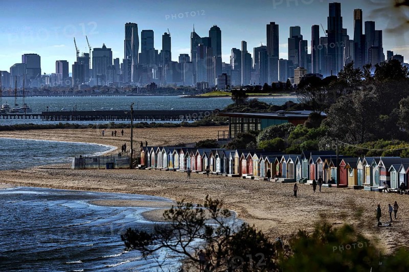 Colourful beach boxes on Brighton beach with views of Melbourne's skyline, Brighton Beach, Victoria, Australia