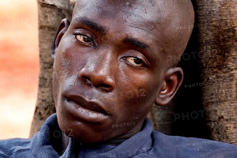 Close-up of an exhausted man outdoors in Bouaké. He seems emotionally burdened, Bouaké, Saint Camille, Nimbo, Côte d'Ivoire