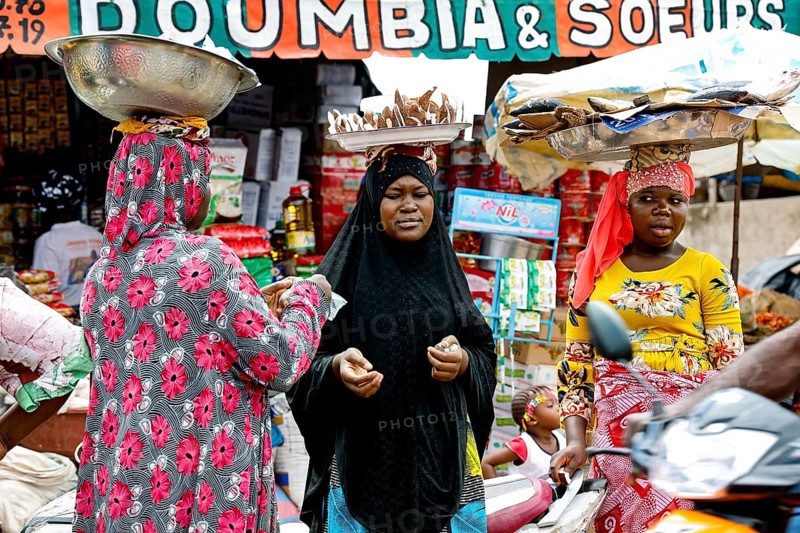 Bustling market with various goods and people in a cheerful atmosphere, CI Bouaké, Ivory Coast