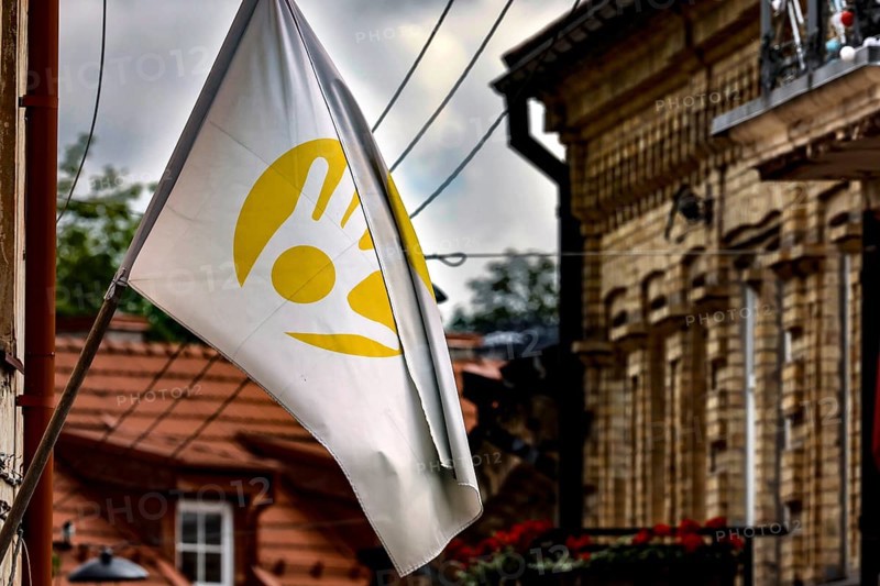 White flag with yellow symbol flying in Uzupis, Vilnius under cloudy sky, Vilnius, Vilnius County, Lithuania