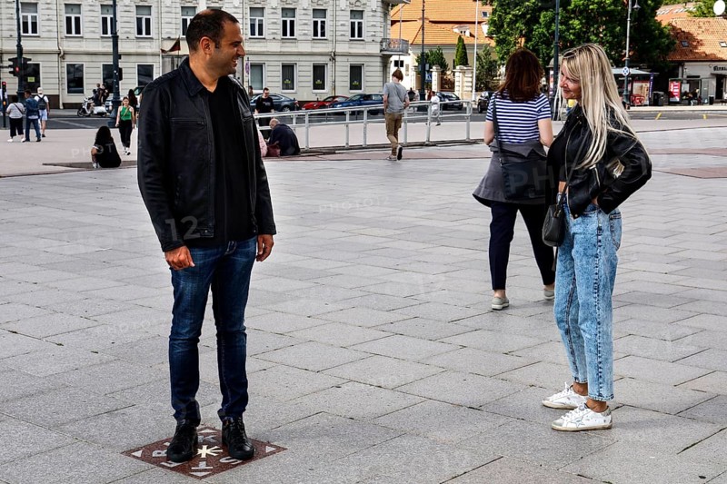 A couple talking on the miracle tile on Cathedral Square in Vilnius, Vilnius, Vilnius County, Lithuania