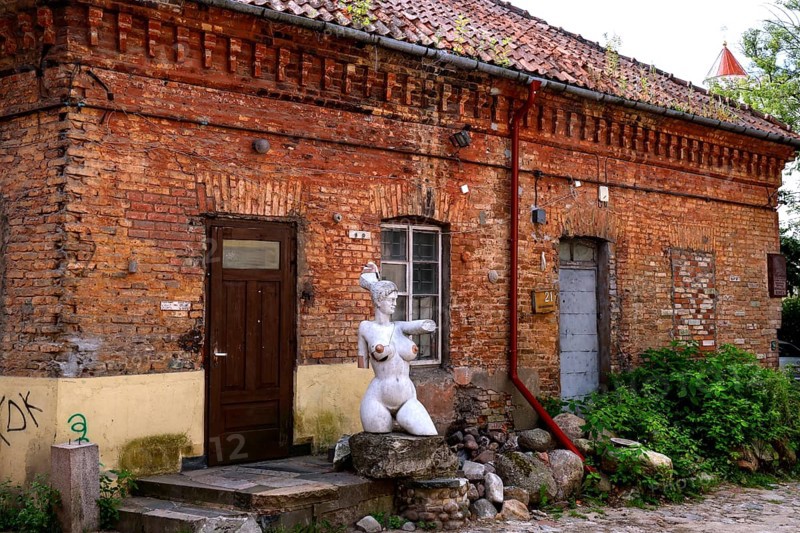 Rustic backyard with brick wall and sculpture in Uzupis, Vilnius, Vilnius County, Lithuania