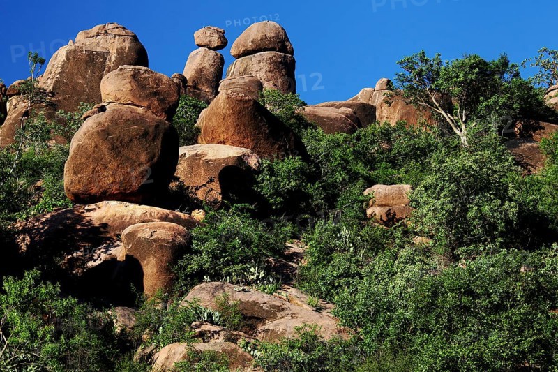 Large rock formations with surrounding vegetation under a clear sky, Babile, Oromia, Ethiopia