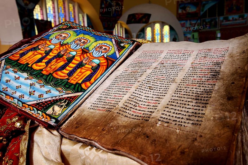 Bible inside St. Mary's Cathedral in Axum shows beautiful stained glass and detailed illuminations, Axum, Ethiopia