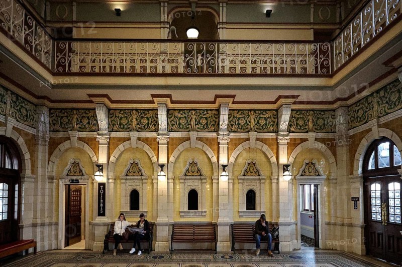 Elegant interior view of Dunedin train station with people on wooden benches, Dunedin, null, New Zealand