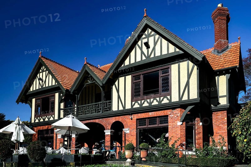Historic Tudor style building with red bricks under blue sky in Mona Vale, Christchurch, Mona Vale, New Zealand