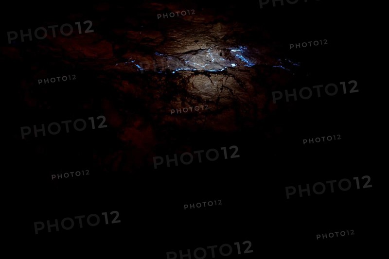 Shiny opalader in a dark layer of rock at Tom's Working Opal Mine, Coober Pedy, South Australia, Australia