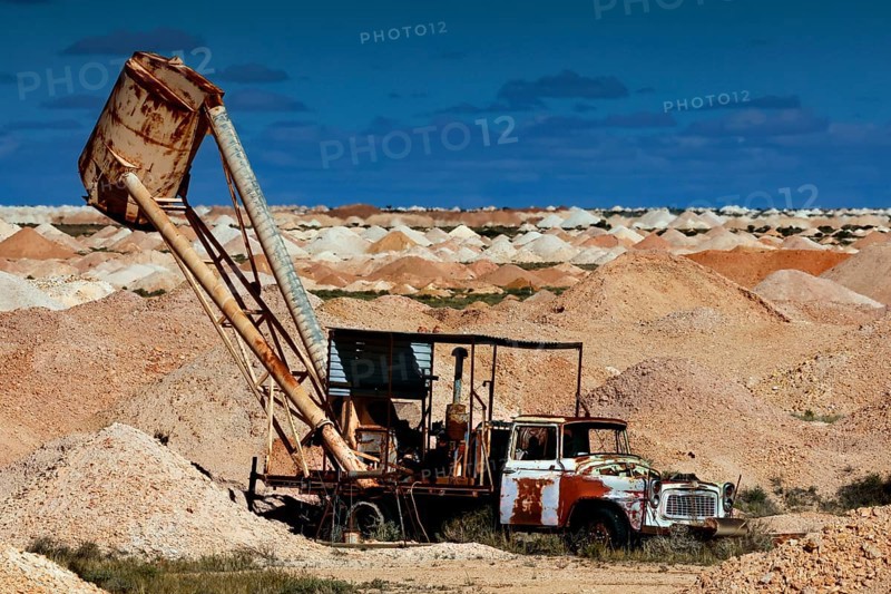 Mining machine in the opal mining area of Coober Pedy, surrounded by desert and blue sky, Coober Pedy, South Australia, Australia