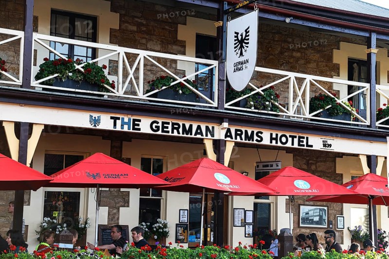 The German Arms Hotel in Hahndorf with red umbrellas under a bright blue sky, Hahndorf, South Australia, Australia