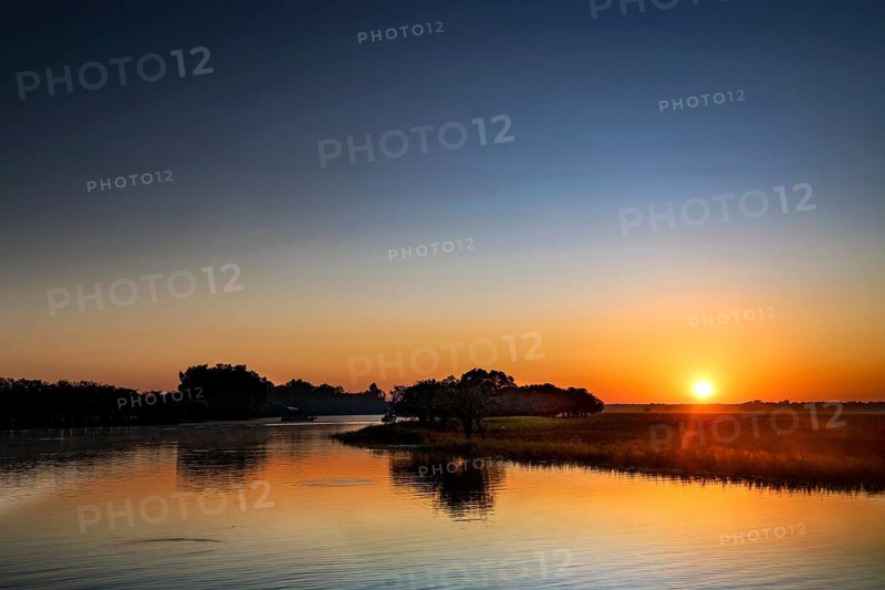 A clear sunrise is reflected in the water in Kakadu National Park, Kakadu National Park, Northern Territory, Australia