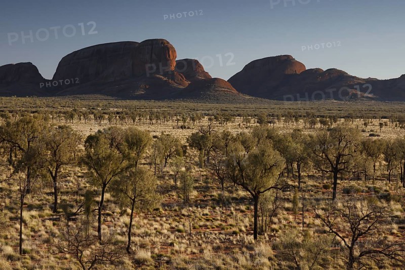 Wide desert-like landscape with distinctive rock formations in the distance, zero