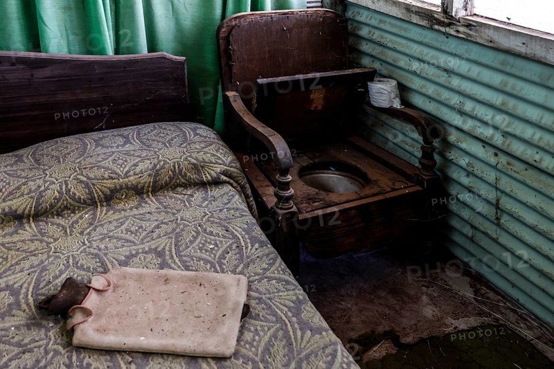 Rustic interior with bed, wooden chair and green curtains, zero