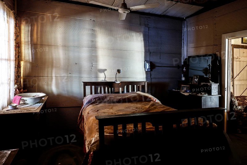 Subdued bedroom with old-fashioned bed and wooden furniture, zero