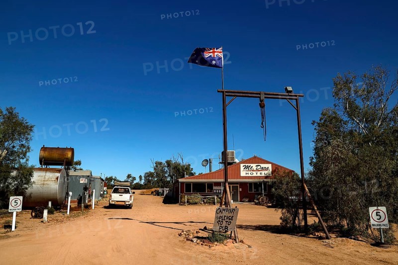 Rustic Mt Dare hotel in remote desert setting with Australian flag, zero
