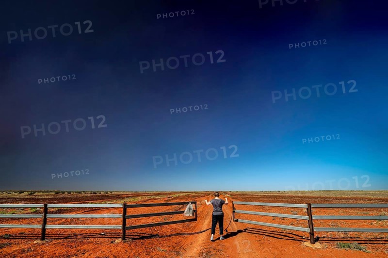 Gate on the Old Andado Track in the red sands of the desert under wide skies