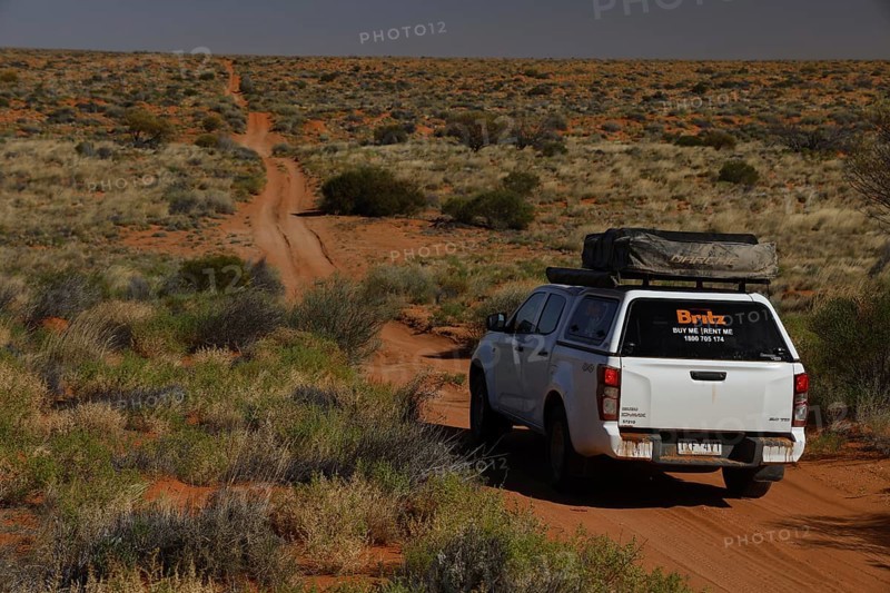 4WD vehicle drives on a dusty sandy track through the Simpson Desert, Simpson Desert, Australia
