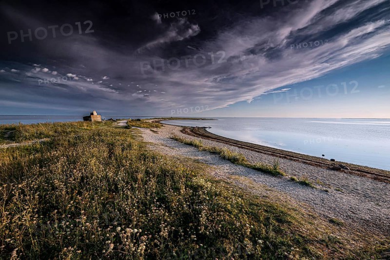 Tranquil stretch of coast with dramatic skies and soft grass, Särve, Saaremaa, Estonia
