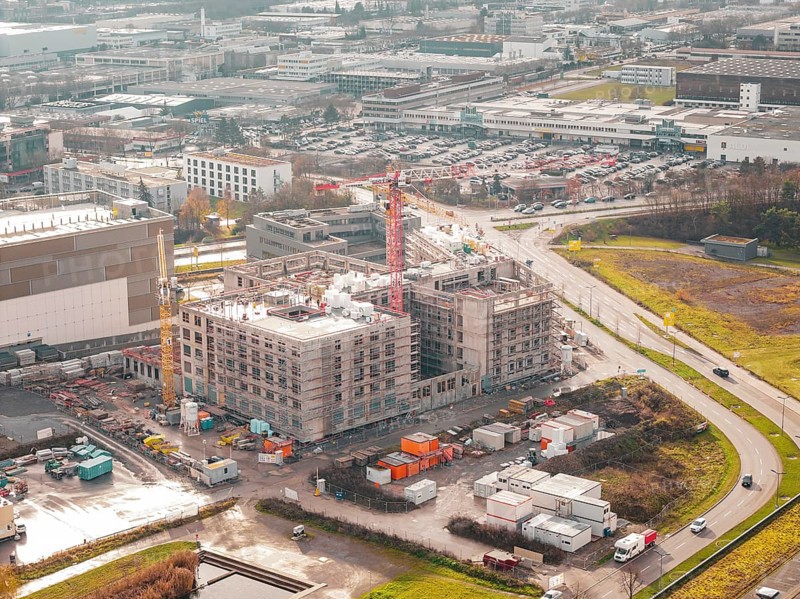 Aerial view of a construction site of a new hospital in an industrial area with buildings and cranes, Böblingen, Germany