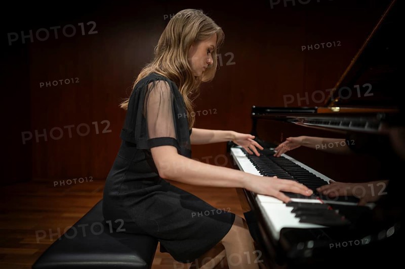 Young woman, pianist, side view playing on a Steinway & Sons grand piano in evening dress, Stuttgart, Baden-Württemberg, Germany