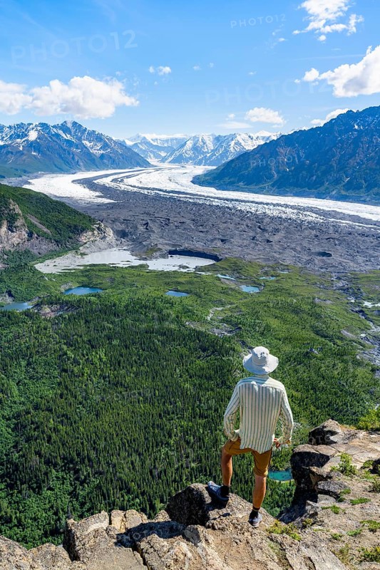 Young man enjoying the view, view of impressive mountain landscape with Matanuska glacier and glaciated mountain peaks, Lion's Head, Chugach Mountains, Alaska, USA