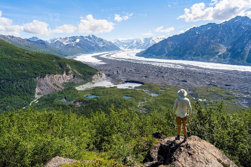 Young man enjoying the view of impressive mountain landscape with the Matanuska Glacier tongue, Lion's Head, Chugach Mountains, Alaska, USA