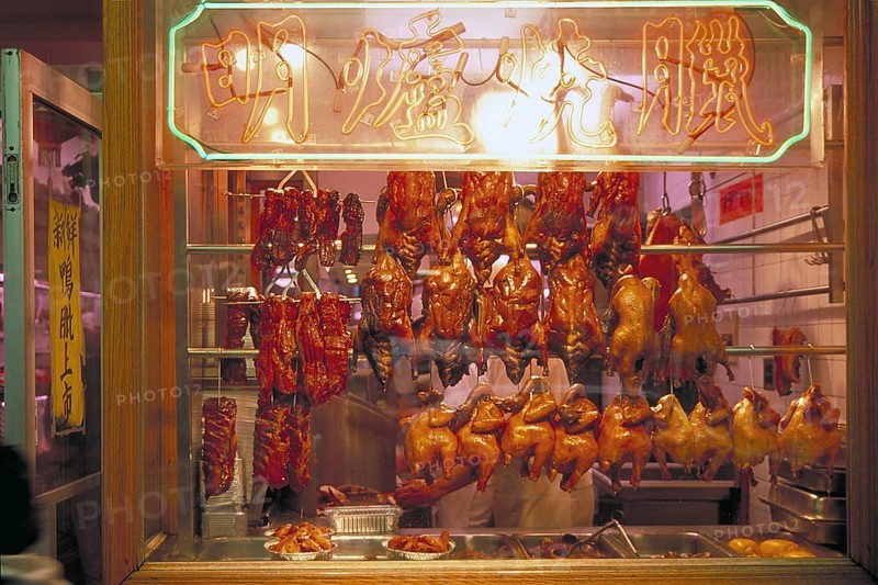 Ready to cook poultry in a shop window in Chinatown, New York City, USA