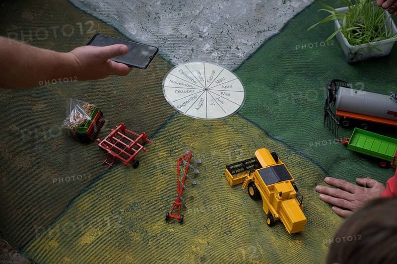 Hand points at a miniature agricultural model with toy vehicles on a table, event for schoolchildren of the Transparency campaign, Osnabrücker Land, Lower Saxony, Germany