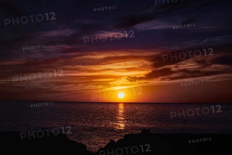 Impressive sunset over the sea with colorful skies and water reflections, Playa Blanca Lanzarote