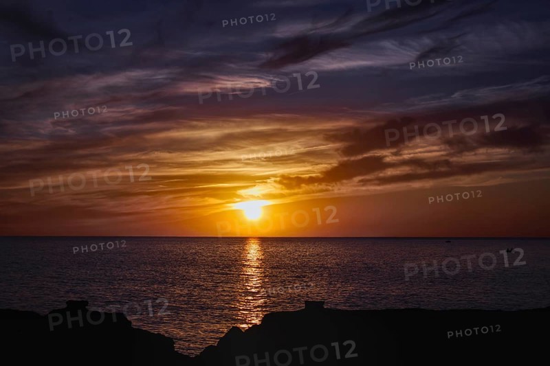 Colourful sunset over the sea with reflective, dramatic cloud formations, Playa Blanca Lanzarote