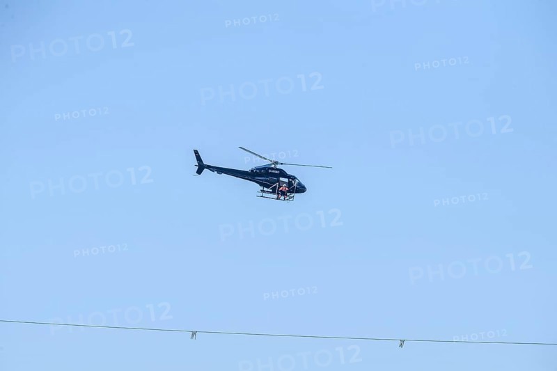 A helicopter flies over a high-voltage line in the air during technical work, Lemförde, Lower Saxony, Germany